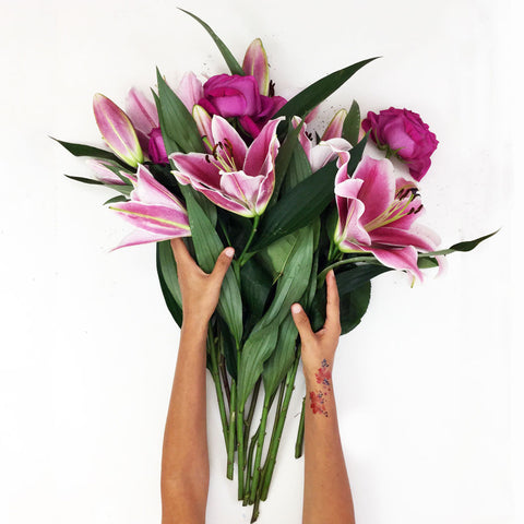 Photo of hands holding a bouquet of lilies and roses by artist CreativeIngrid | Ingrid Sanchez. London 2018.