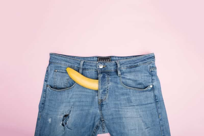 Blue jeans with banana poking out of the zipper of the jeans