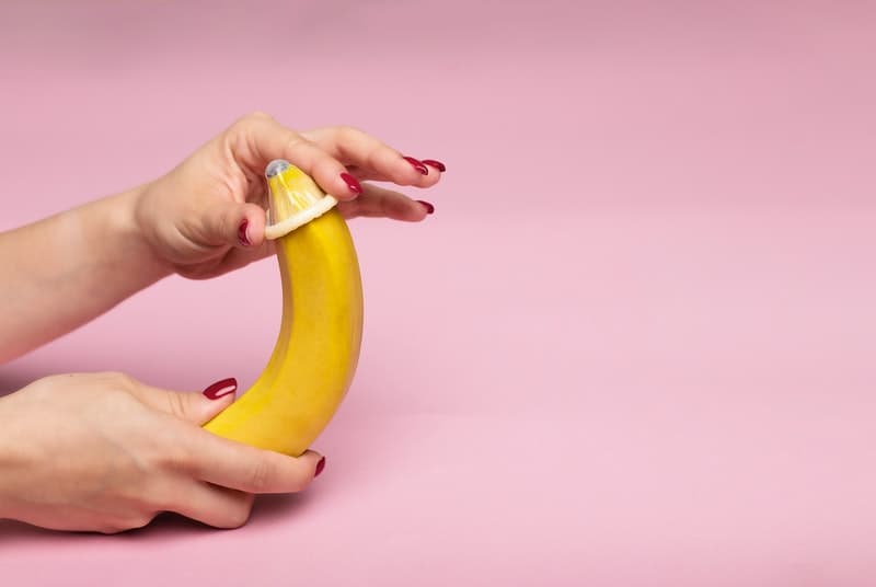 Condom being put on an unpeeled banana