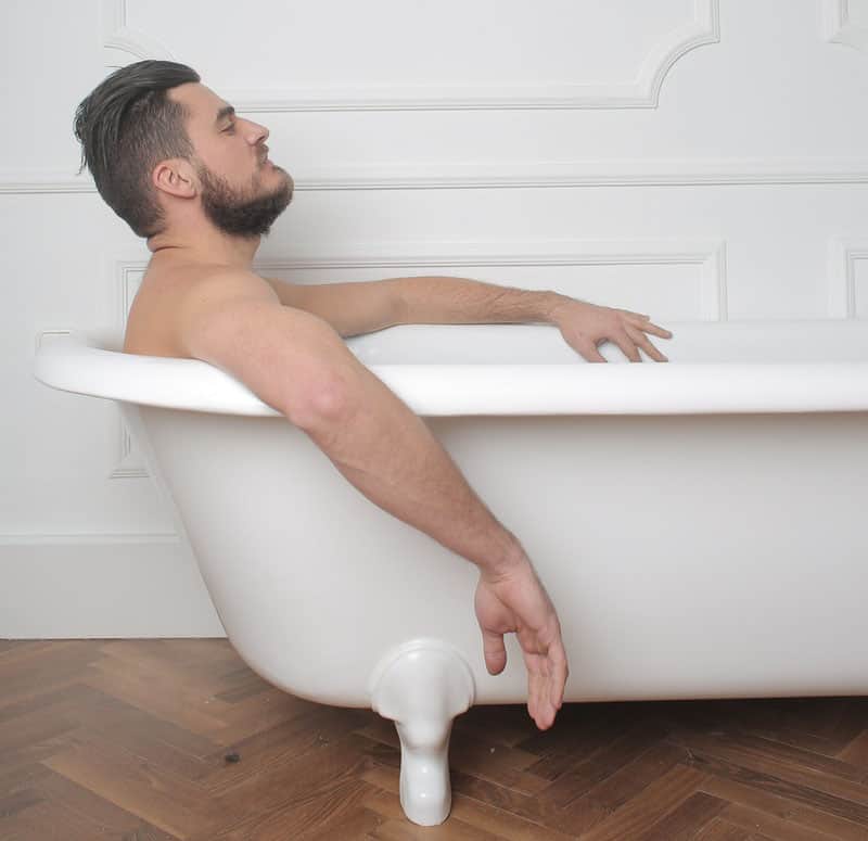Man in bathtub cleaning to prevent smegma