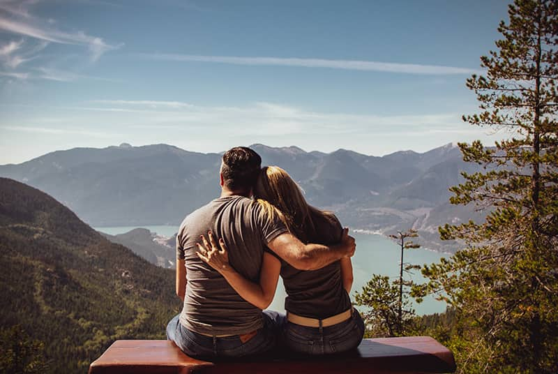 Sexually active adult couple sitting on bench