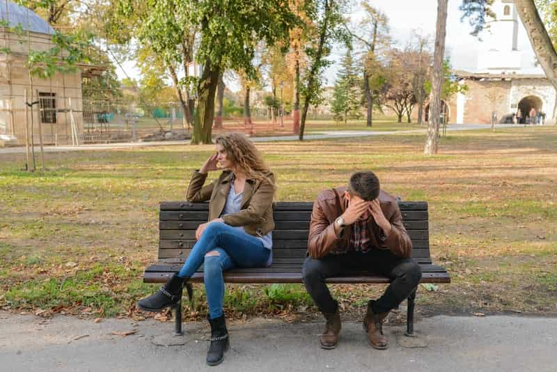 Unhappy couple sitting on a park bench