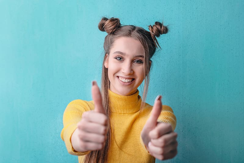 Woman with two thumbs up for penis measurement