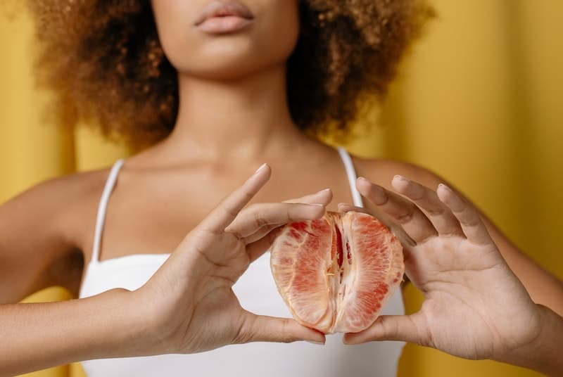 Woman holding vagina shaped fruit to represent vaginal sensitivity