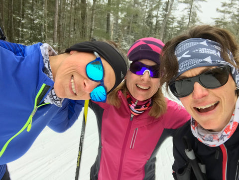 Three smiling skiers pose for a portrait