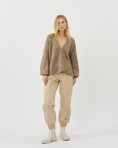 model standing wearing the Minimum Women's Melsa Cardigan in Nomad paired with beige joggers and off white chelsea boots