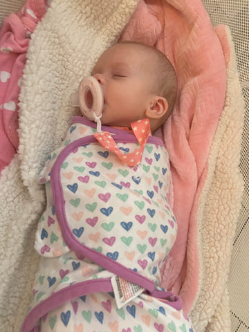 Swaddled baby girl with ninni pacifier