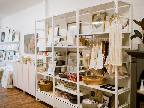 Photo of curated home goods displayed on white shelves at Pink Lemon Decor store