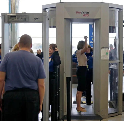 woman walking through airport scanner