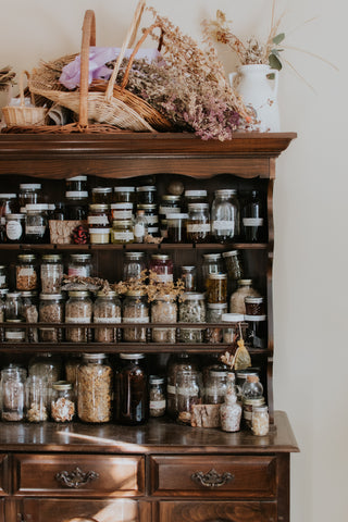 apothecary, herbalism, nutrition, herbal hutch filled shelves full of jars of dried herbs