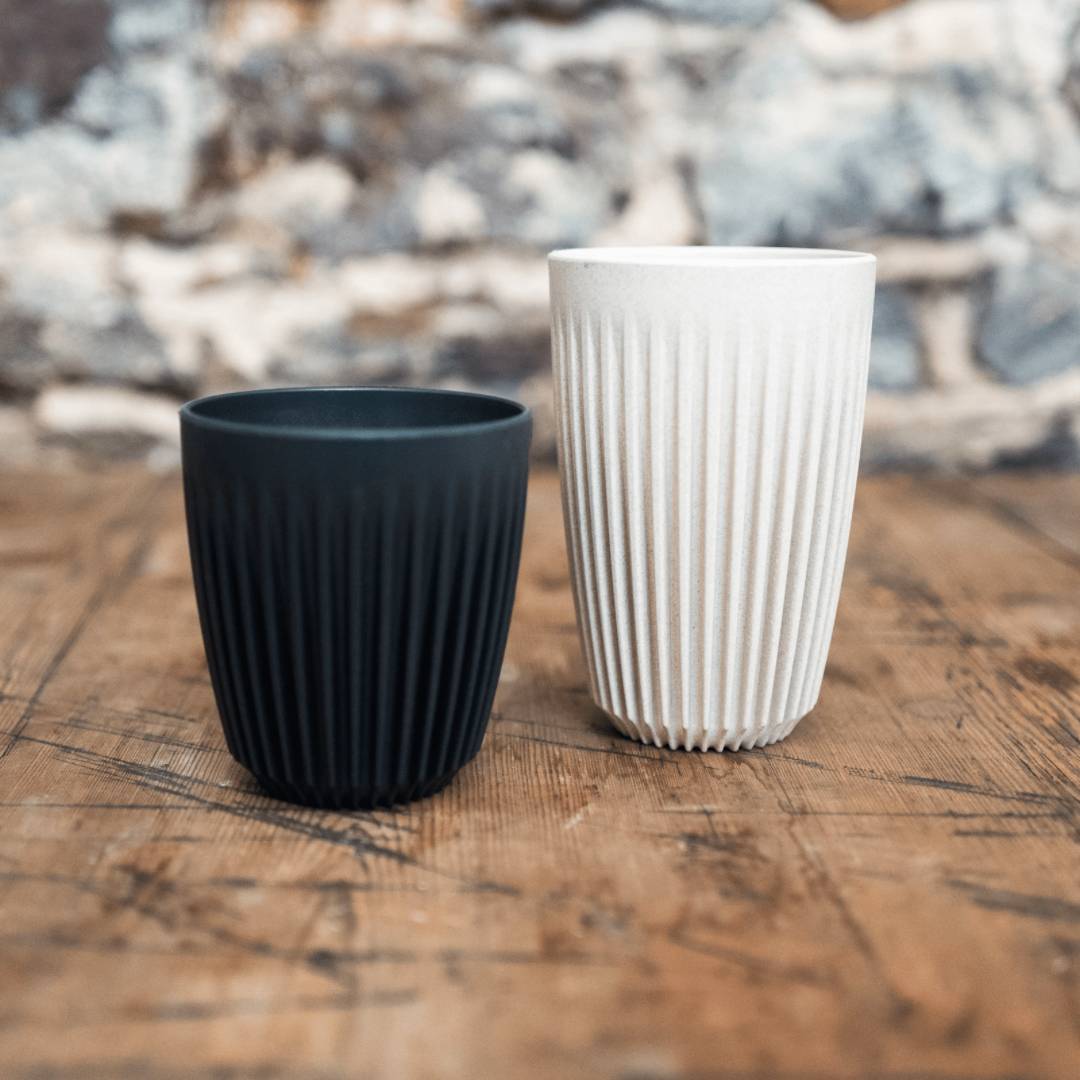 hand holding reusable coffee cups