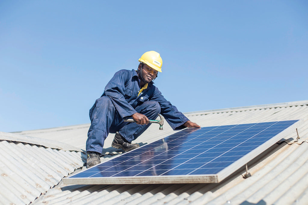 Ein Mann installiert eine Solarzelle auf einem Dach