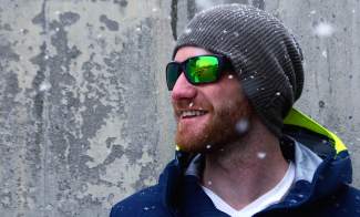 smiling man in cold weather wearing native eyewear green mirror sunglasses