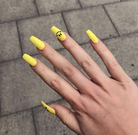 Yellow nails with smiley faces in black
