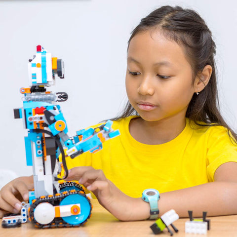 girl playing with lego robot