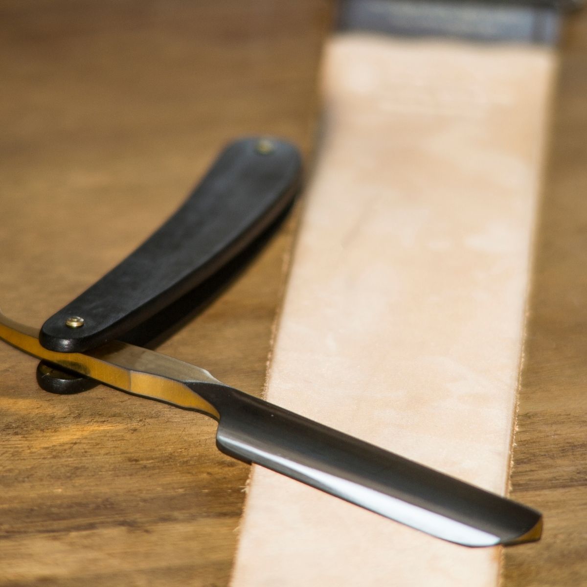 A straight razor getting sharpened with a strop