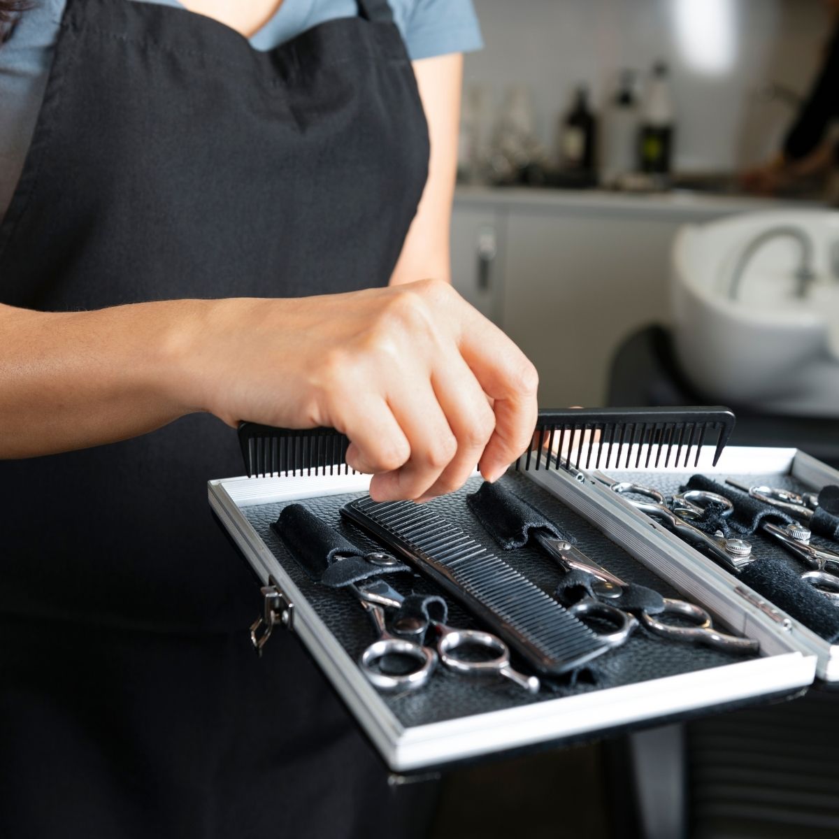 A hairstylist protecting her shears inside of a scissor case