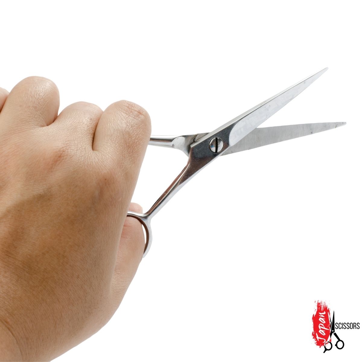 Fryzjer mierzący nożyczki do strzyżenia włosów na swojej dłoni
