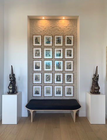 Twin white pedestals frame home display of Thai art