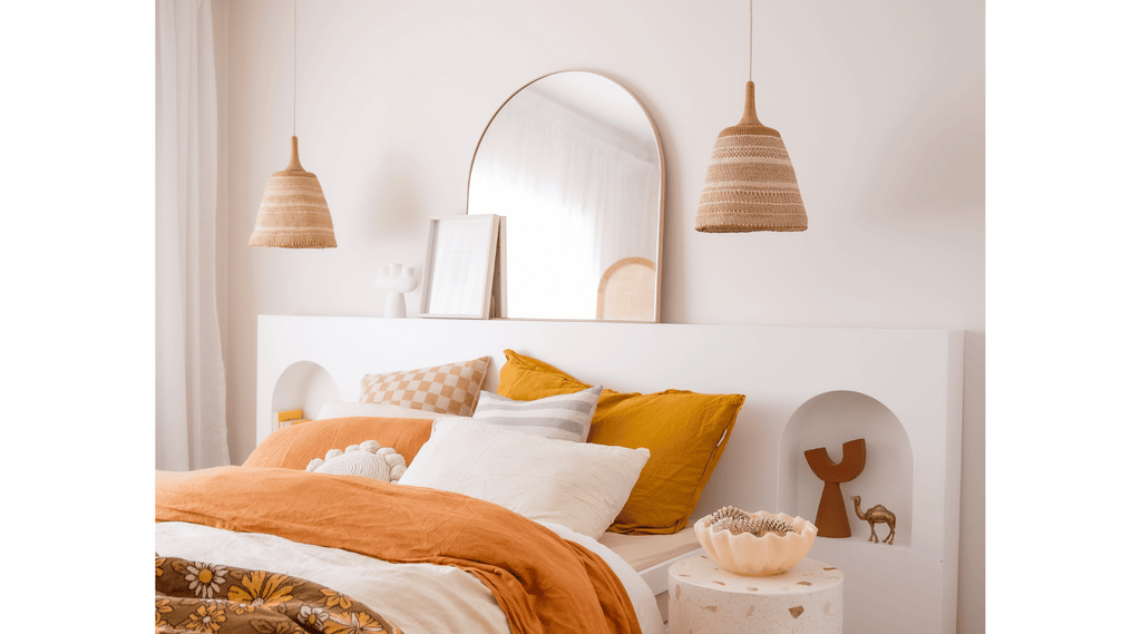 Two pendant lights hanging next to a bed