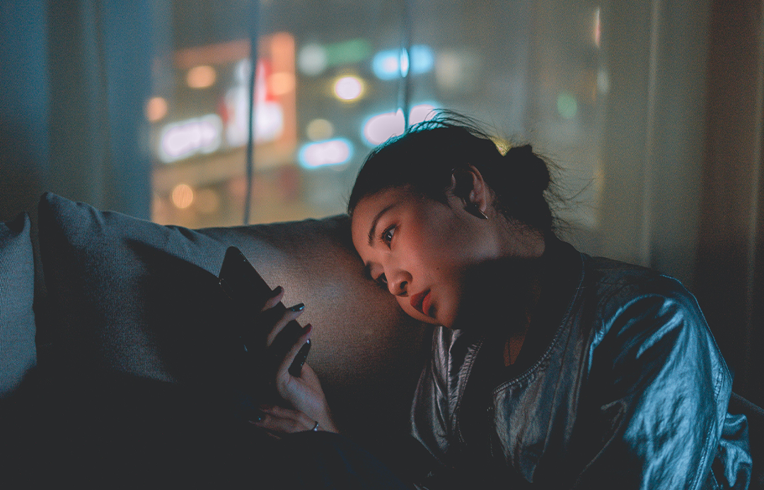 girl reading her phone at night