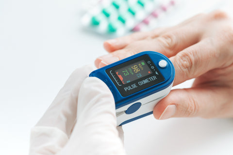A person checking oxygen level with an oximeter