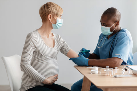 Pregnant woman wearing mask with a doctor 