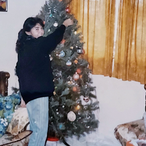 Photo of Jessica from the '80s, standing in front of her grandparents' Christmas tree