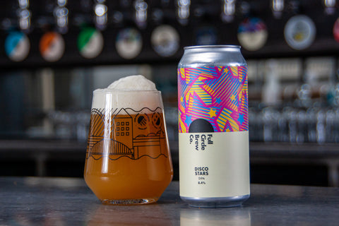 Can of the latest brew from Full Circle, a Double India Pale Ale, 8.4%, consisting of Grapefruit, Citrus and Tropical Fruit Flavours. With a glass full of the alcoholic beverage sat on top of a bar.