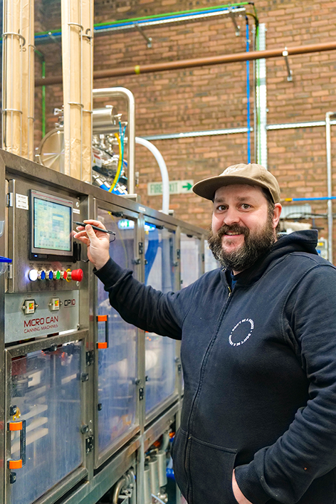 a male brewer working on the canning line