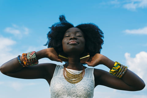 dark skinned woman natural afro hair facing the sky