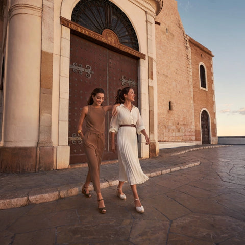Two women in black and white espadrille wedges walking around Mediterranean city. Handcrafted espadrilles made in Spain.