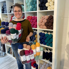 Tracy holding two shopping baskets fully of Germantown Bulky in gorgeous colors. Available at Stixyarn.com and the shop in Bozeman, Montana