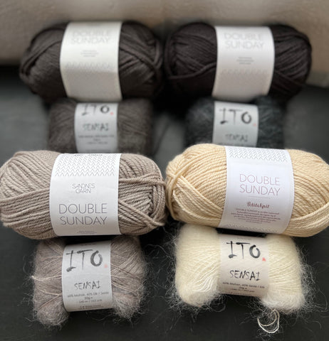 perfectly matched neutral shades of wool and mohair yarns on a dark surface