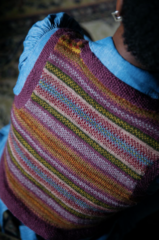 the back of a knitted vest flecked with many muted shades