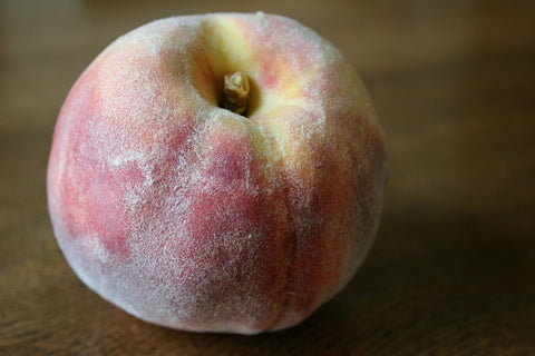 image of a peach fruit on a wooden surface