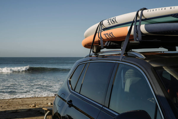 SUP boards strapped to a car roof rack