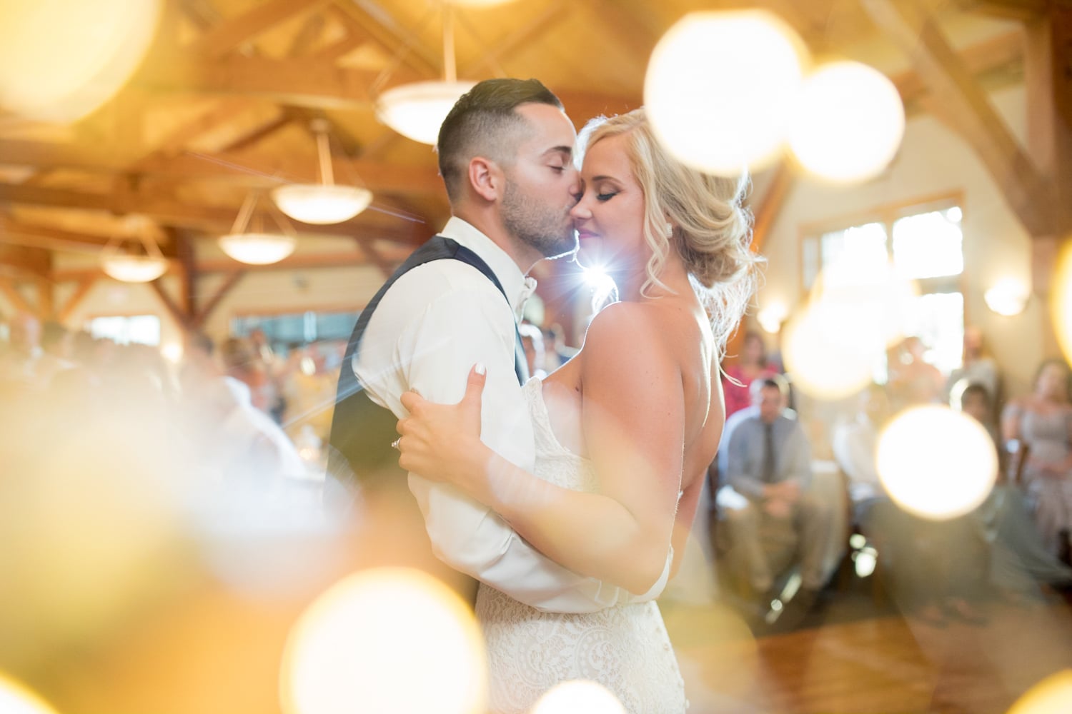 A bride and groom are pictured dancing with twinkling lights on the edge of the photo