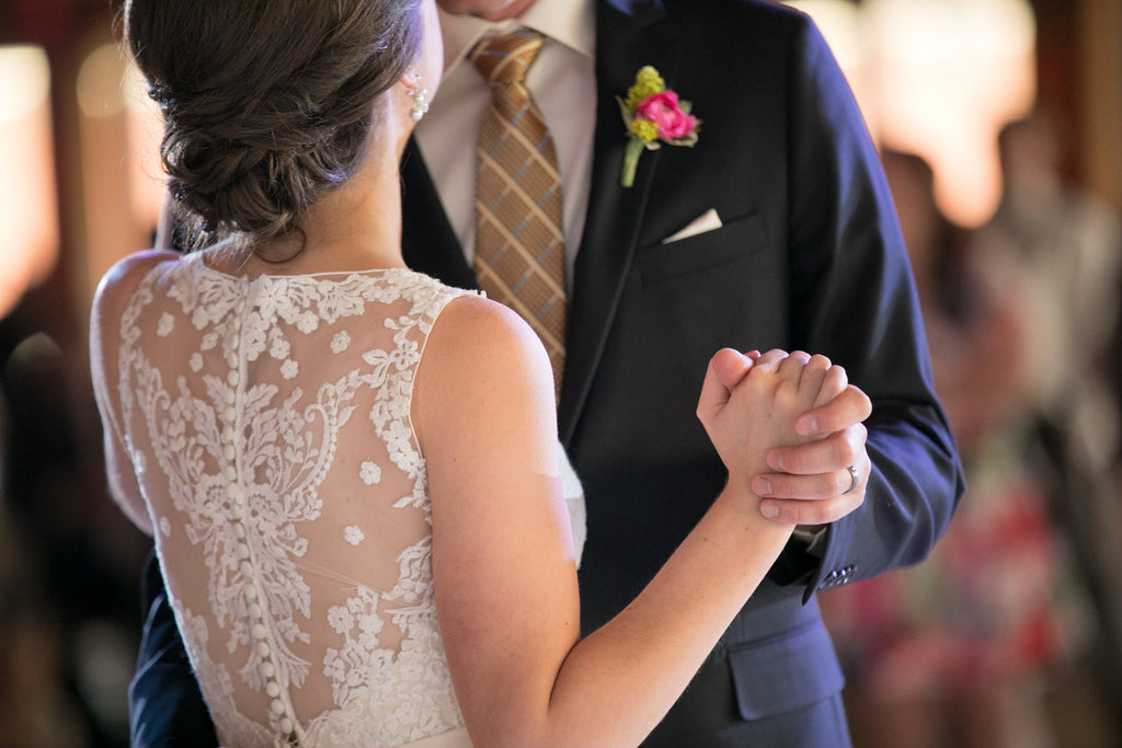 A closeup of a bride dancing with someone on her wedding day