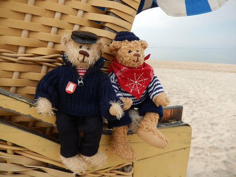 Two teddy bears at the beach