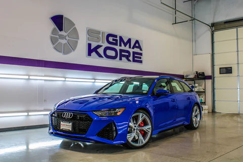 Image of a shiny, blue BMW in a Sigma Kore garage to convey the benefits of Ceramic Coating Denver