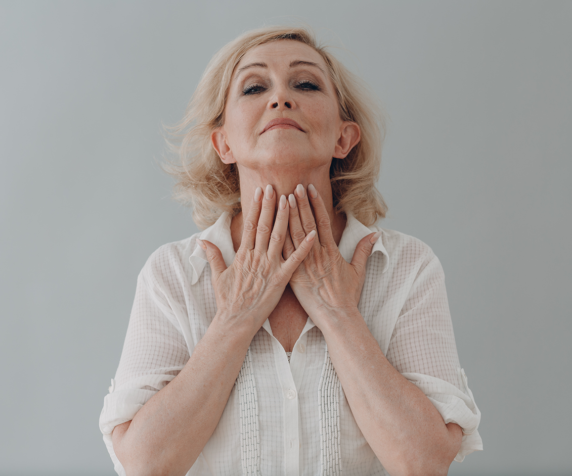 an older woman touching her neck