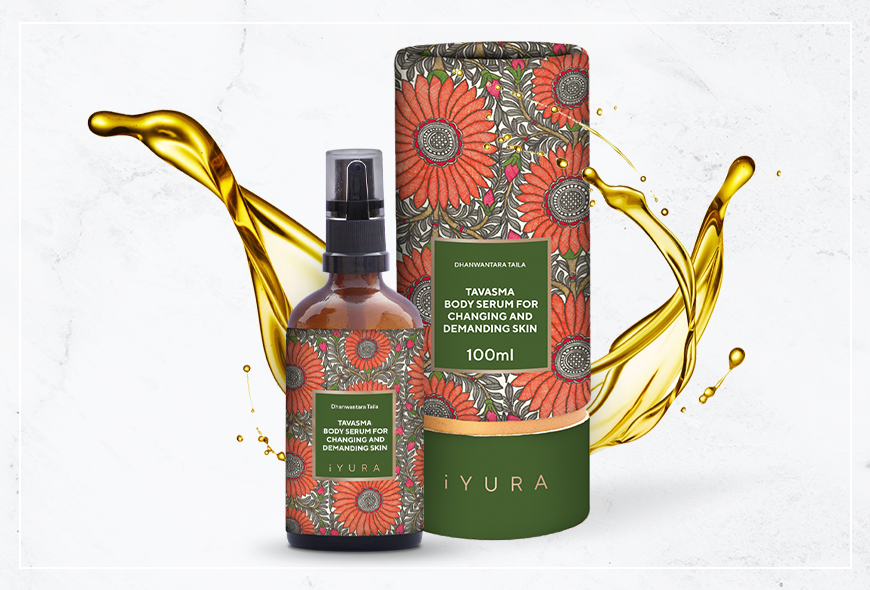 a beautiful photo of Manjish Glow Elixir - iYURA's bestselling night oil - accompanied by its beautifully illustrated, protective cylinder packaging