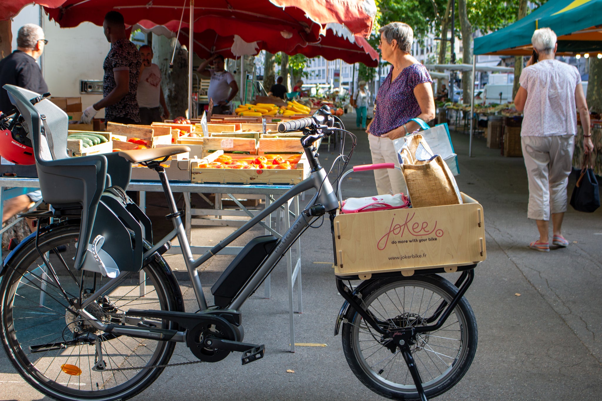 Fourche cargo JoKer Mini avec caisse en bois installée sur un VAE au marché