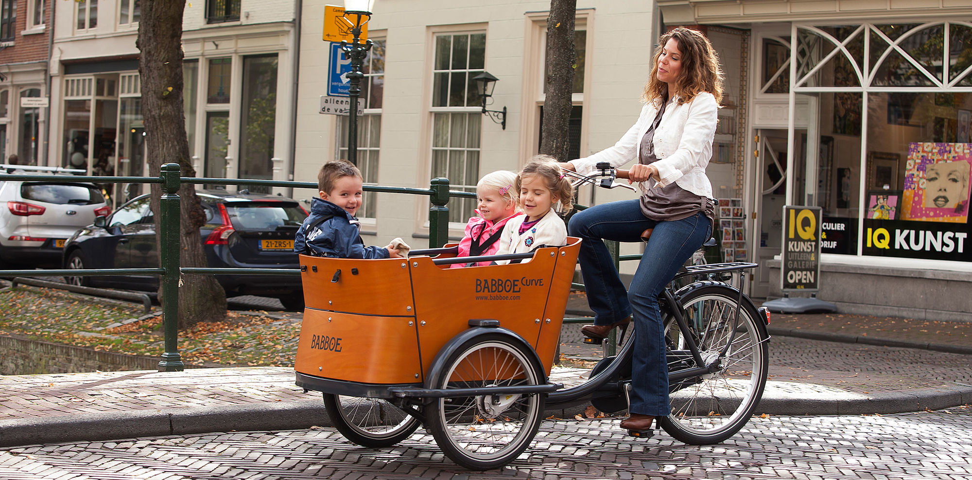 Transporter 3 enfants dans la caisse du triporteur Babboe Curve