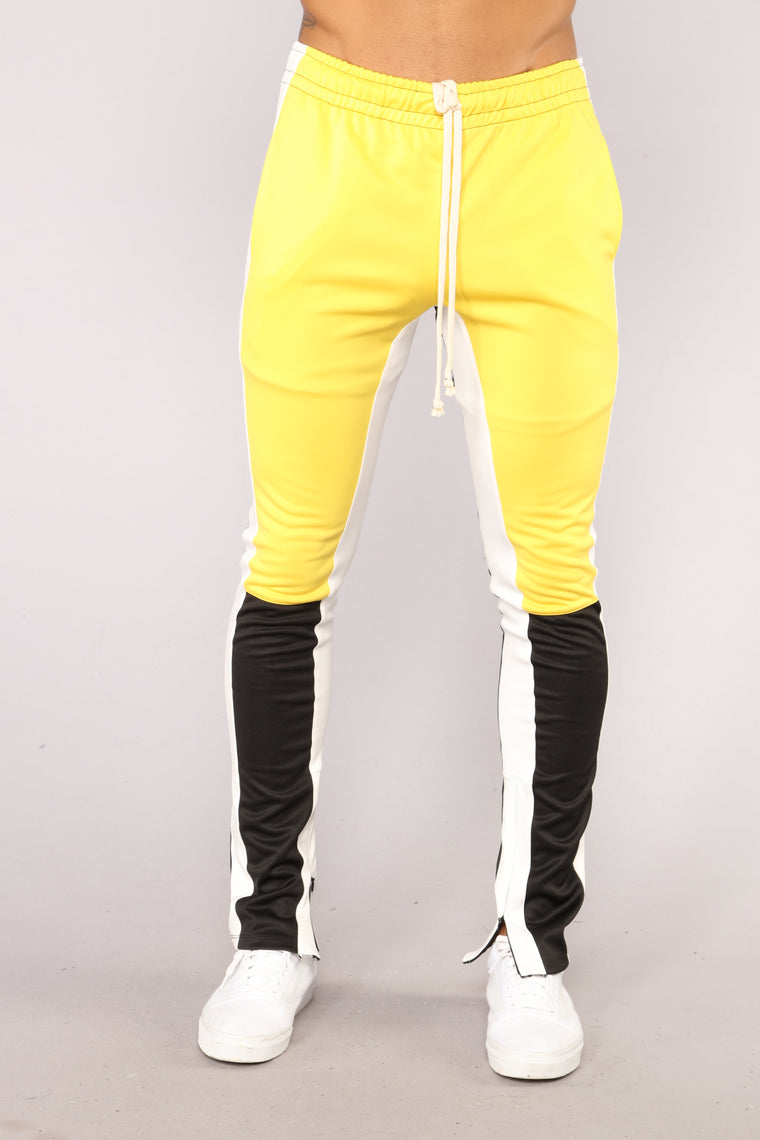 yellow track pants with black stripe