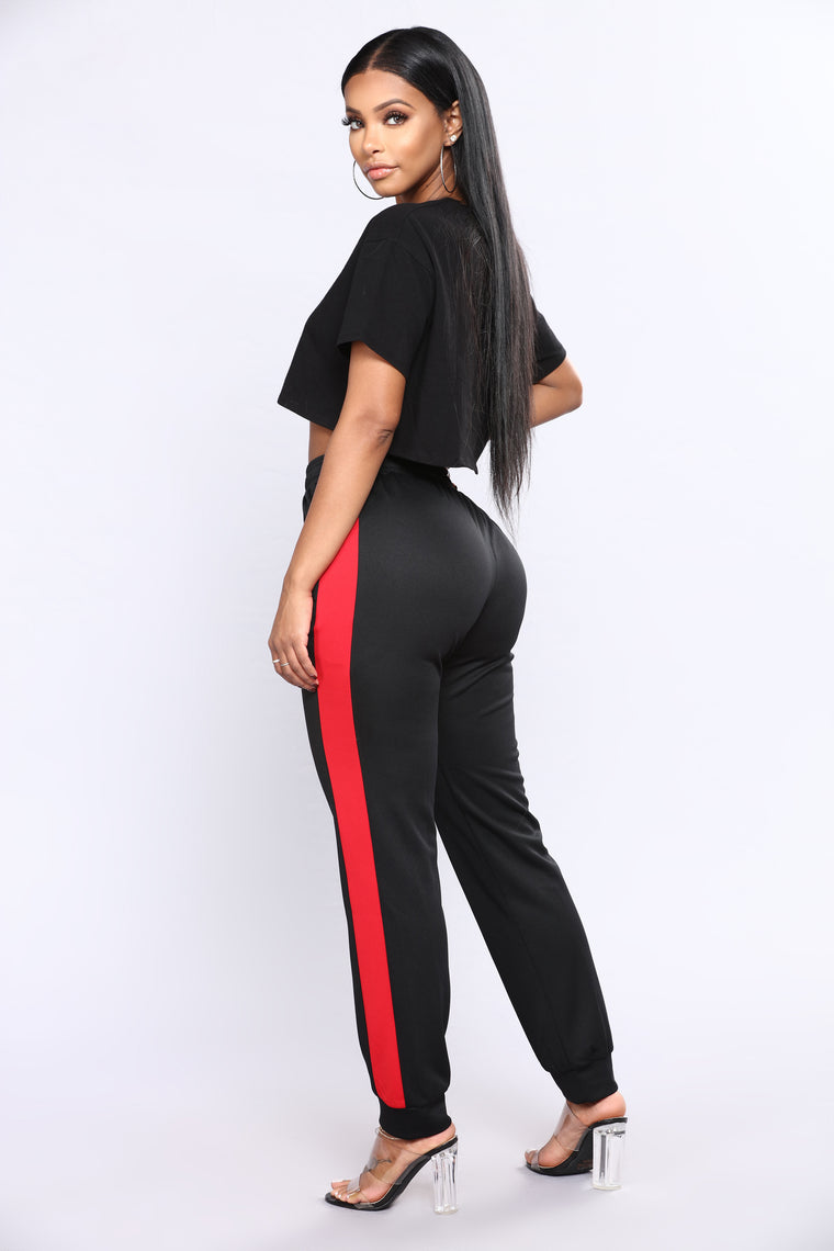 black tracksuit bottoms with red stripe