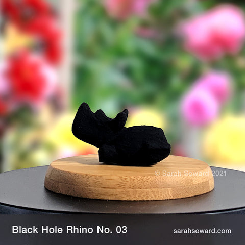 Black Hole Rhino sculpture number 03 on a bamboo stand