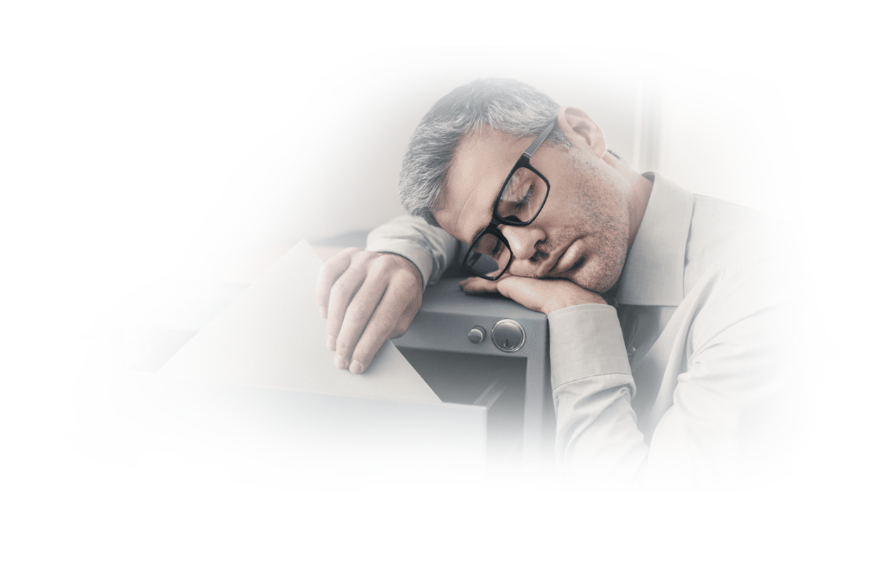 Image of young man with glasses sleeping while leaning on office filing cabinet because he suffers from narcolepsy.