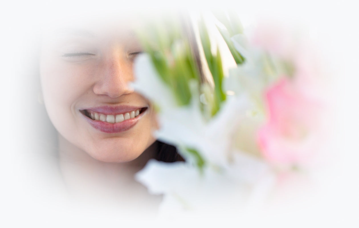 Image of woman smiling behind white flowers